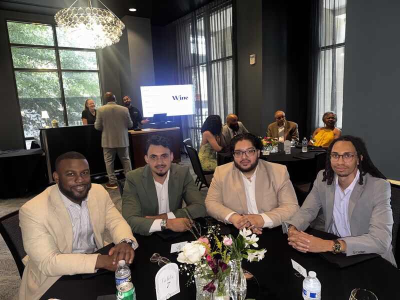Four Mainline Strategies team members seated together at a dinner table during a company event